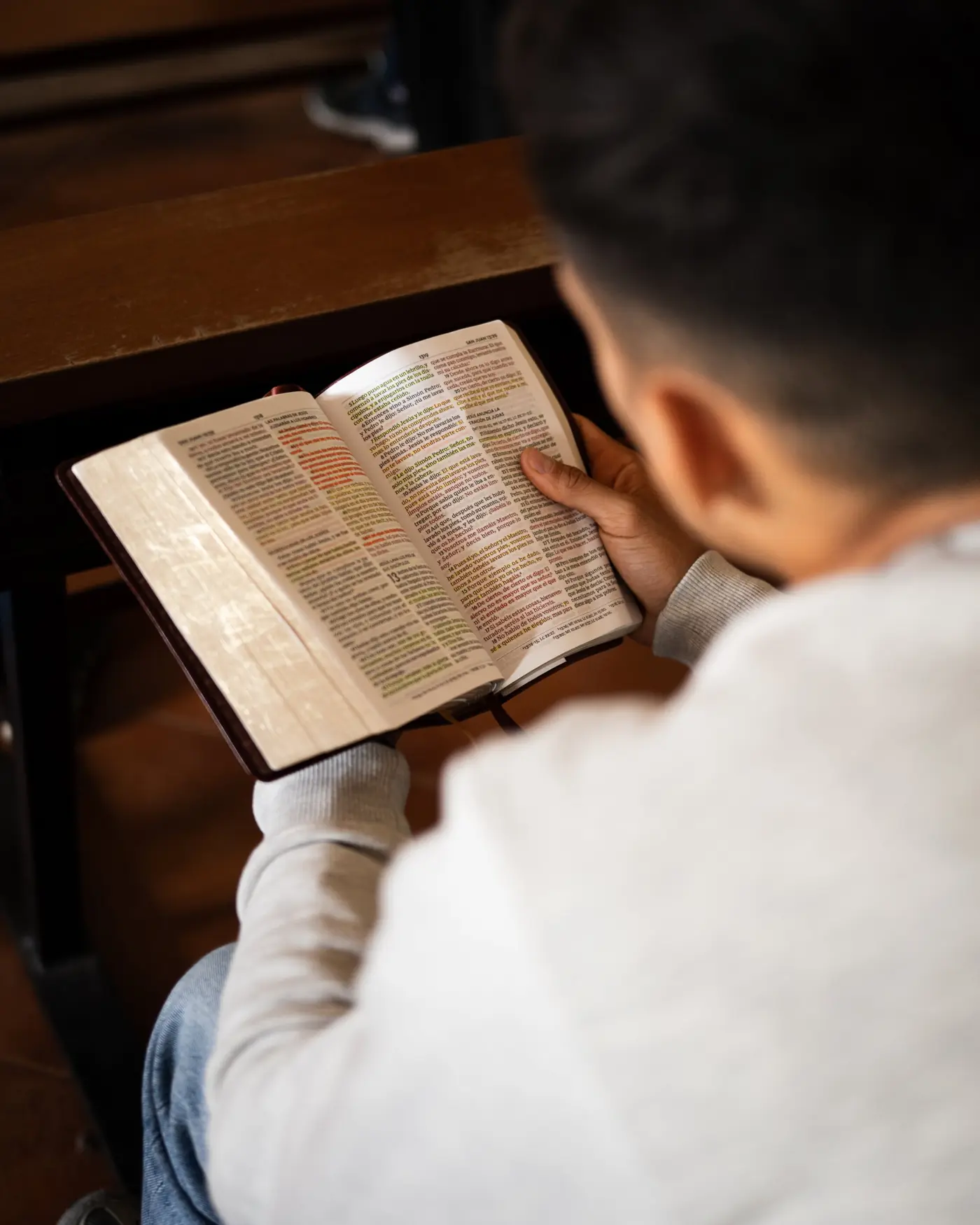 Un joven lee la Biblia durante una reunión